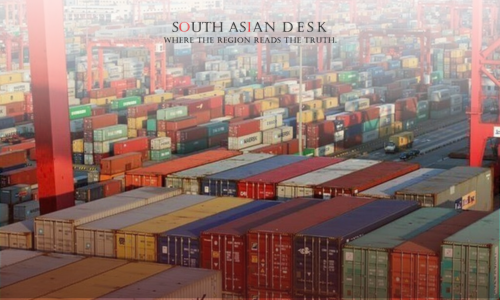 A busy port with numerous colorful shipping containers stacked high, red cranes overhead, and a cityscape in the background.