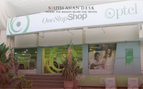 The exterior of an PTCL OneStopShop store with a sign and promotional posters in the windows.