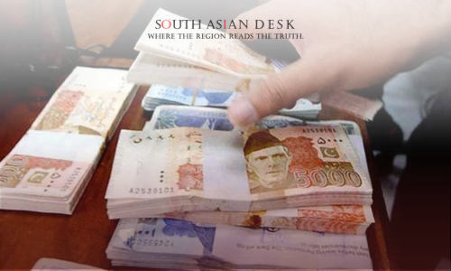 A hand counting stacks of 5000 Pakistani Rupee notes on a table.