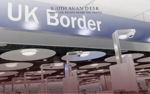 A modern UK Border control area with a blue sign displaying "UK Border" overhead, featuring automated passport control booths, surveillance cameras, and circular ceiling lights in a busy airport terminal.