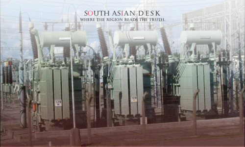 Three large electrical transformers in an outdoor substation, surrounded by a fence and power lines under a clear blue sky.