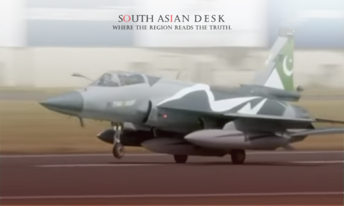 A Pakistani military jet taking off or landing on a runway, with a blurred background of billboards and a building.