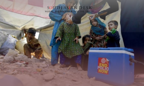 Three New Polio Cases Reported in Pakistan in 2025 1 A group of children and an adult under a tent, with one child receiving a polio vaccine from a health worker. A blue cooler with "End Polio Now" written on it is in the foreground.