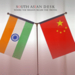 Two flags, China and India, displayed side by side on a single stand against a white curtain backdrop.