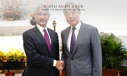 Indian Foreign Minister in a black suit shaking hands with the Chinese Minister wearing a Grey Suit during India and China Talks