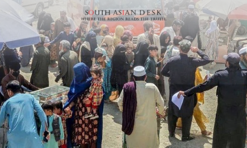 Afghan migrants with belongings at a border crossing amid forced deportations.