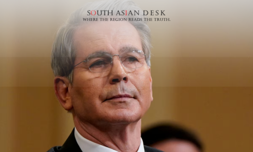 A man with glasses wearing black suit