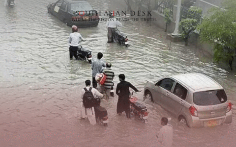 A flooded street with people wading through water depicts monsoon deaths and injuries