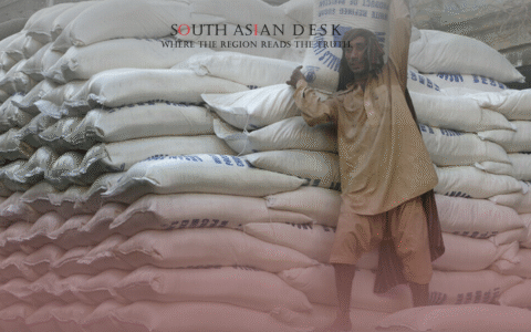 A person in traditional clothing carrying a sack of sugar as Pakistan allows new sugar tender