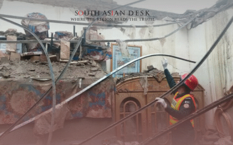 Rescue workers in red helmets and orange vests operating in a damaged building after Lahore Electrocution incident