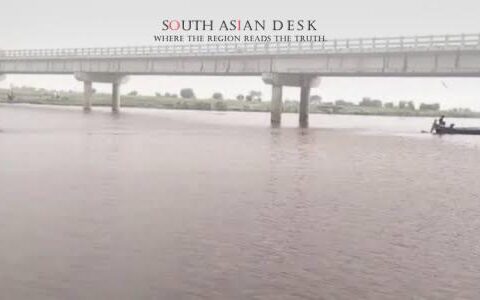 Bridge over a flooding river in South Asia, highlighting infrastructure challenges and transport disruptions during heavy monsoon rains.