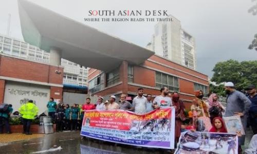 Bangladeshi Protesters holding banners and photographs demonstrate outside a government building, demanding the resignation of Asif Nazrul.