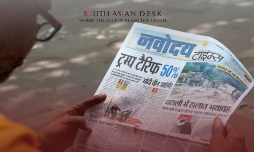 a man with glasses reading india news about US weapons on roadside